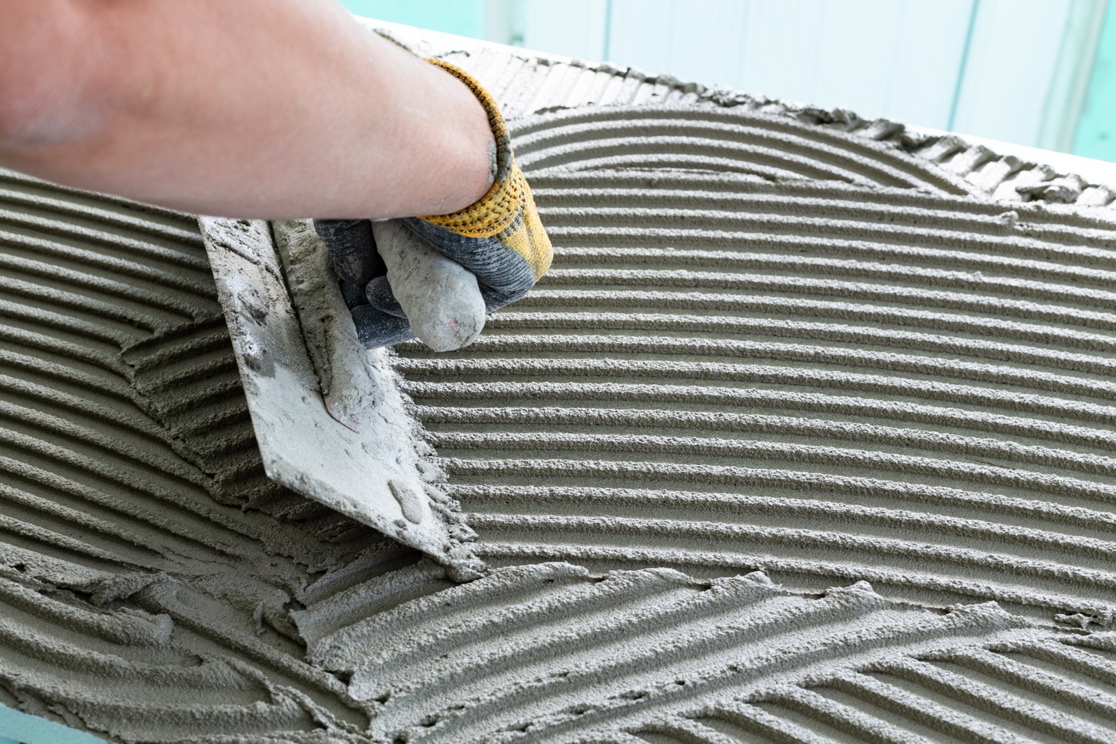 construction,worker,bricklayer,applies,adhesive,mortar,with,trowel,on,xps