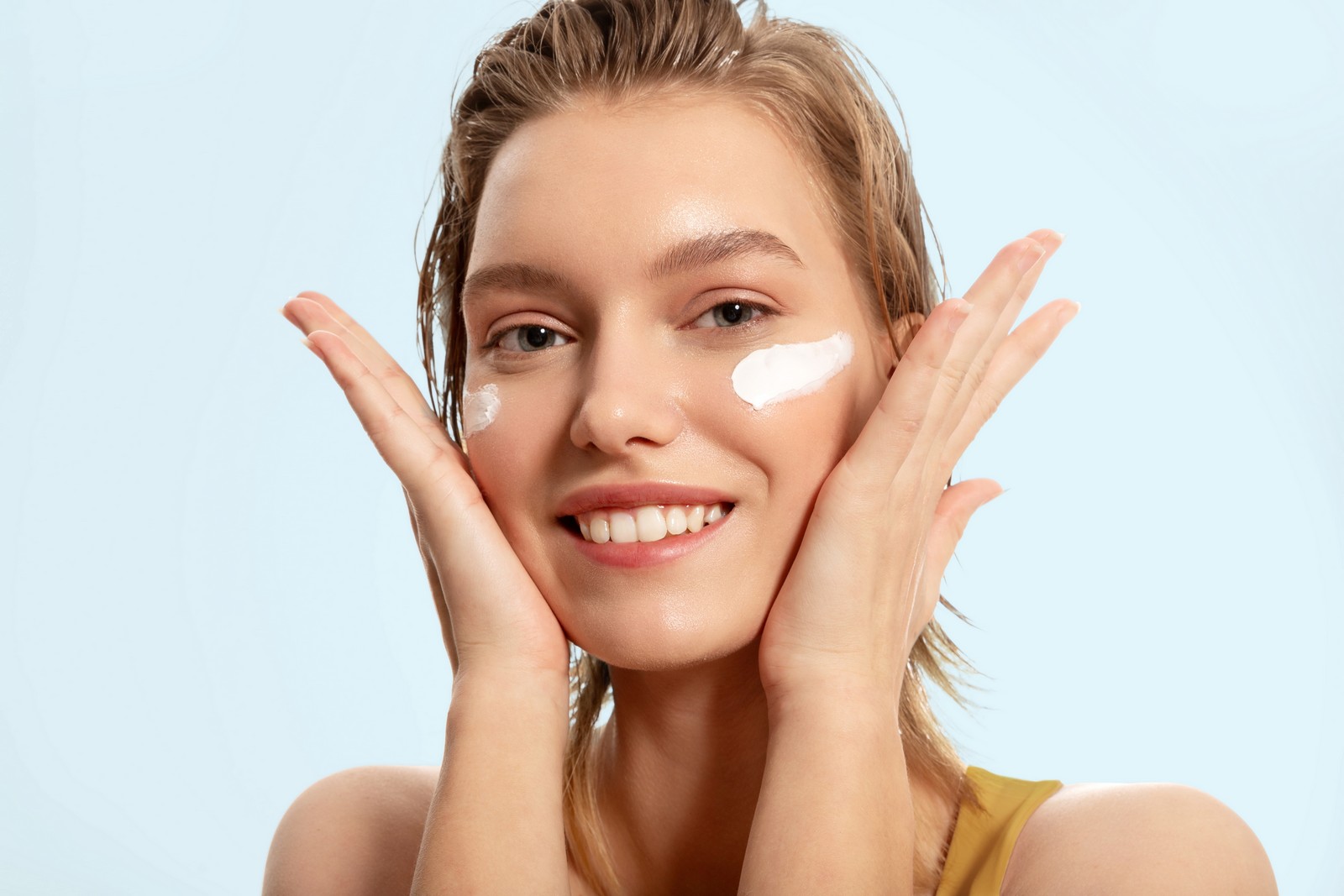 smiling,woman,put,cream,on,her,face,,protection.,cream,protects